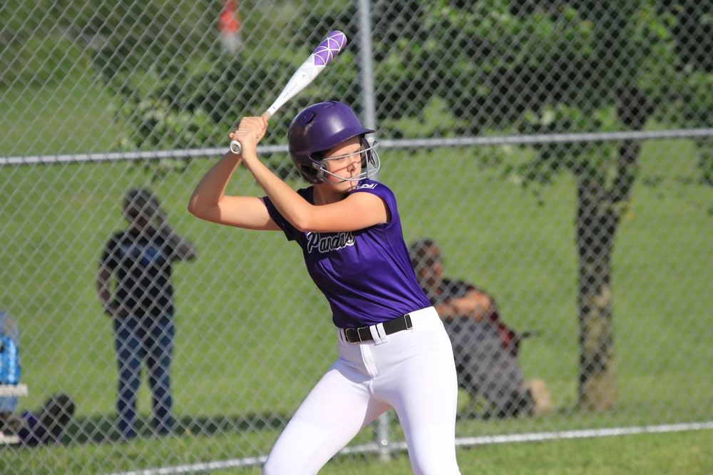 A Winchester Little League softball player fielding during a game.