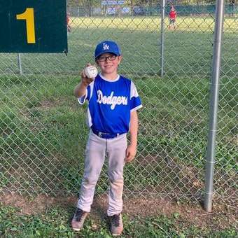 A young Winchester Little League batter waiting on deck during a 2023 game.