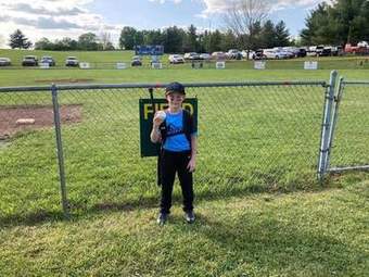 A young Winchester Little League player in uniform standing near home plate in 2023.