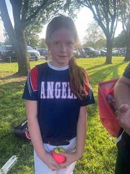 A Winchester Little League player smiling by the fence in 2023.