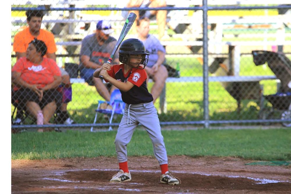 A Winchester Little League baseball player in a batting stance at home plate.